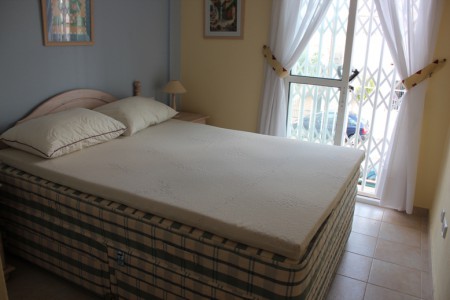 Ett sovrum med continental dubbelsäng och AC samt takfläktar och fransk balkong